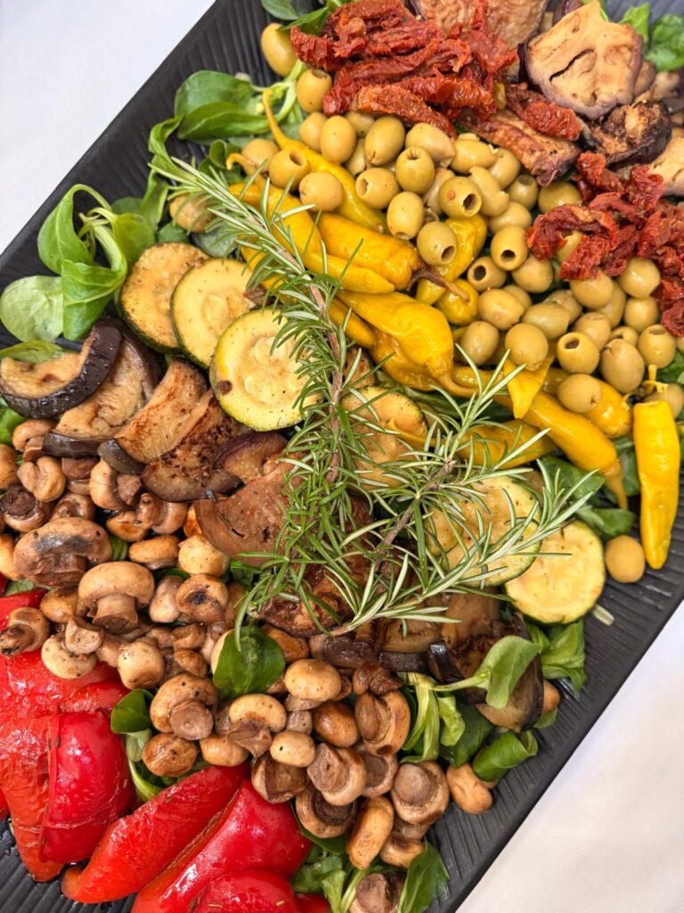Mediterrane Antipasti-Platte mit Oliven Pilzen Zucchini und frischem Rosmarin